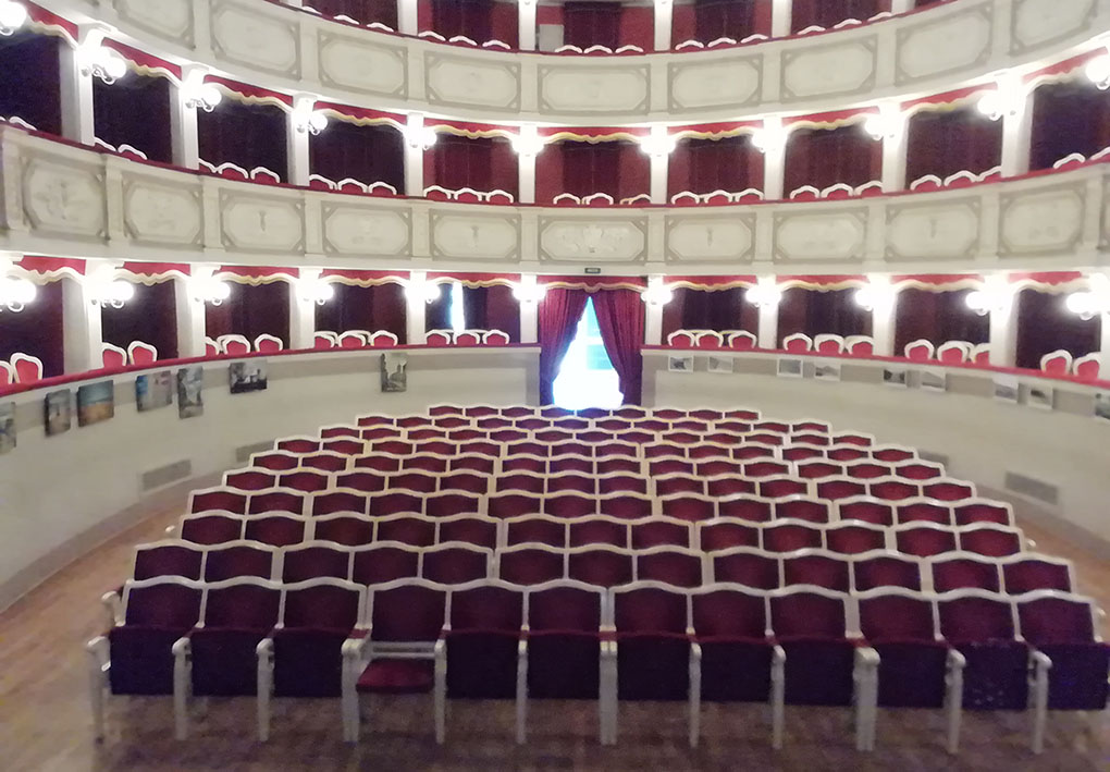 Ampia platea nel teatro di stile ottocentesco, con intorno tre piani di palchetti a forma di anfiteatro