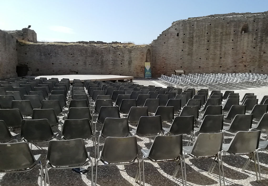 nel cortile di una rocca sorge un palcoscenico. Intorno ad esso, numerose sedie costituiscono la platea.
