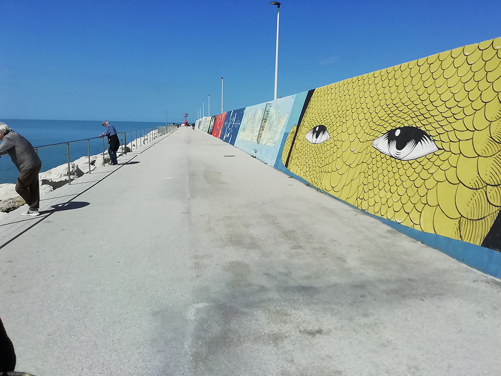 murales decorati ai lati di un'ampia spianata sul mare