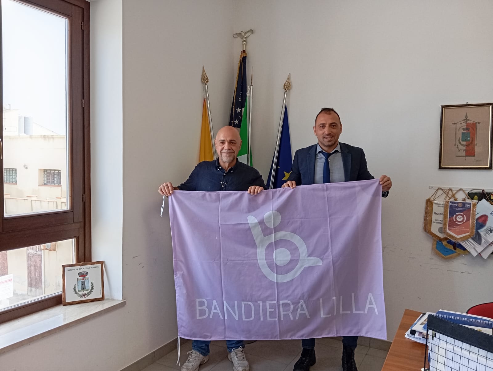 Il Sindaco e il presidente di Bandiera Lilla posano con in mano la Bandiera Lilla