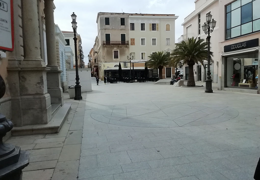 una via del centro storico, con ampi spazi, palme e lampioni