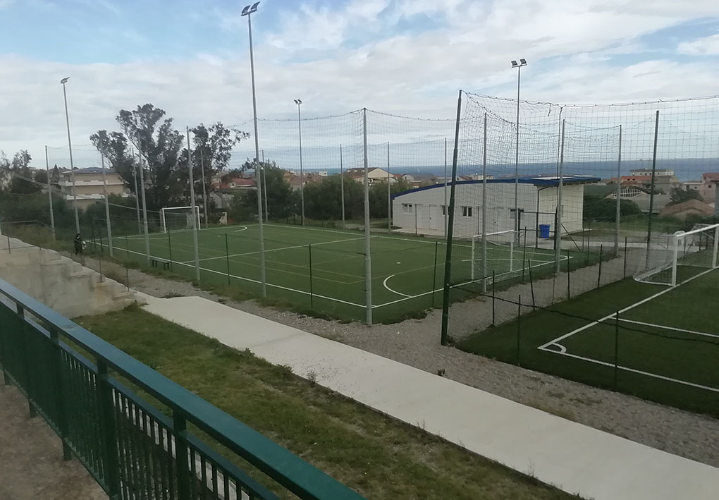 vista dall'alto e dalla strada dei campi da gioco. Sul lato si notano i gradoni degli spalti