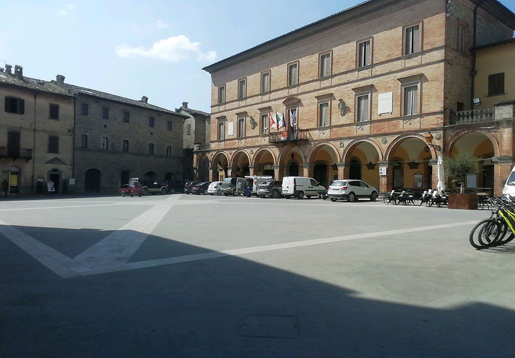 Un palazzo storico con porticato che si affaccia sulla piazza principale