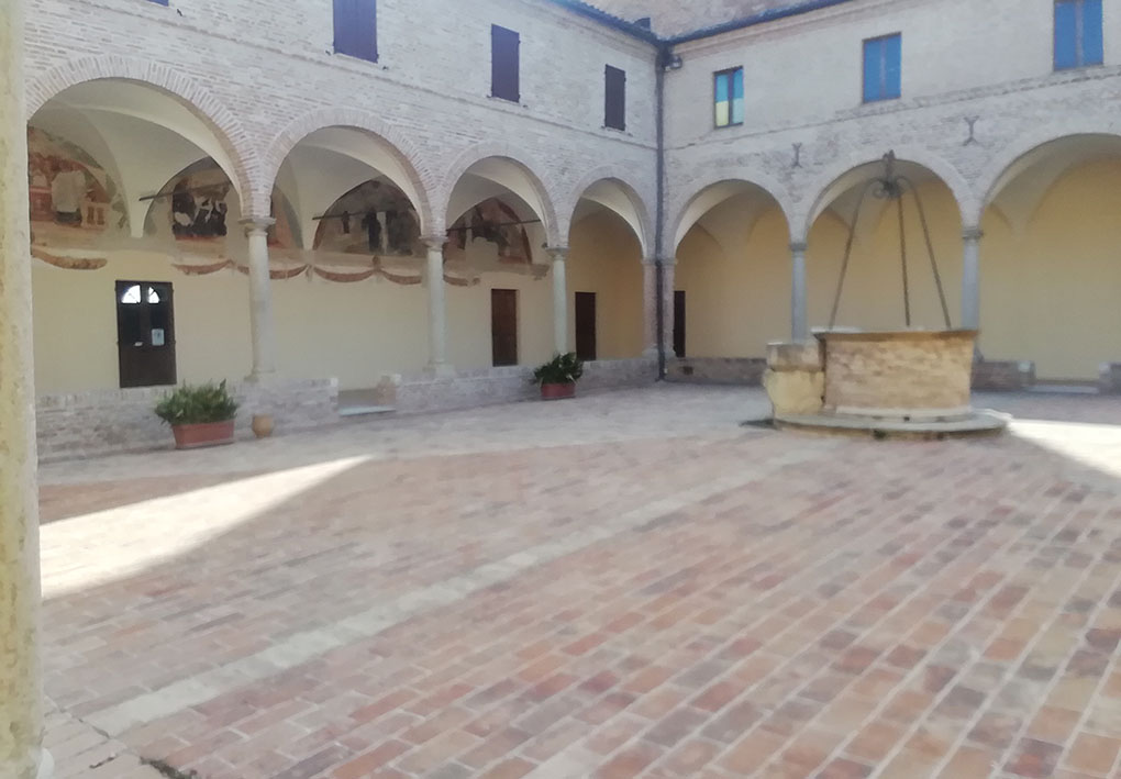 cortile interno dell'antico palazzo, con portici lungo i lati e un pozzo centrale