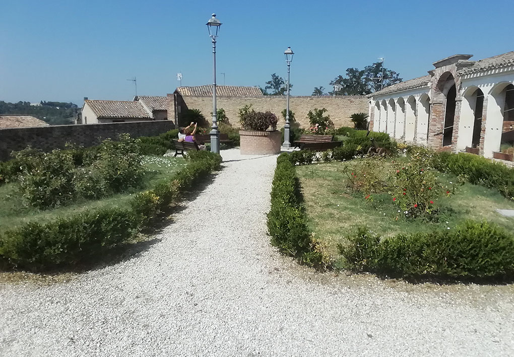 Giardino esterno all'edificio, Aiuole disegante sono distribuite nel piazzale, tra vialetti in ghiaino