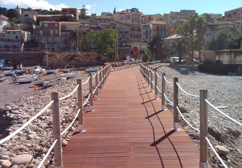 Ampia passerella di legno che attraversa la spiaggia, creando un percorso panoramico