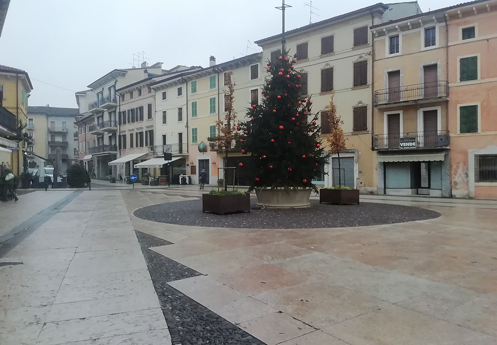 Una parte della piazza, dove si affacciano bassi palazzi variopinti. Al momento dello scatto al centro della piazza sorgeva un albero di Natale