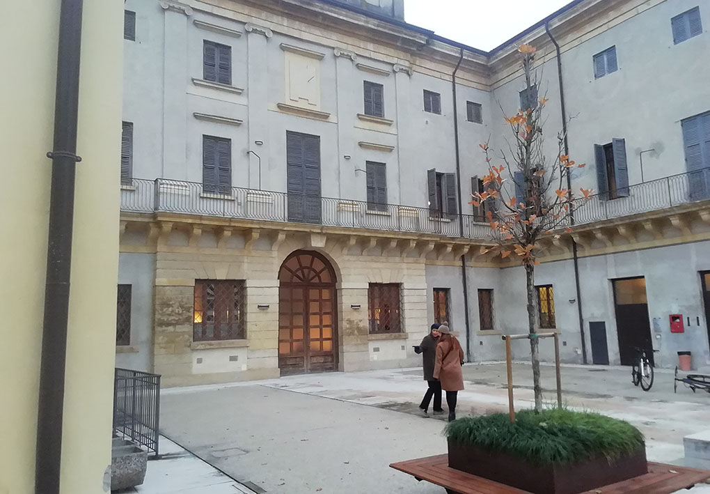 Un cortile di un palazzo antico restaurato di recente, a cui si può accedere da un grosso portale.